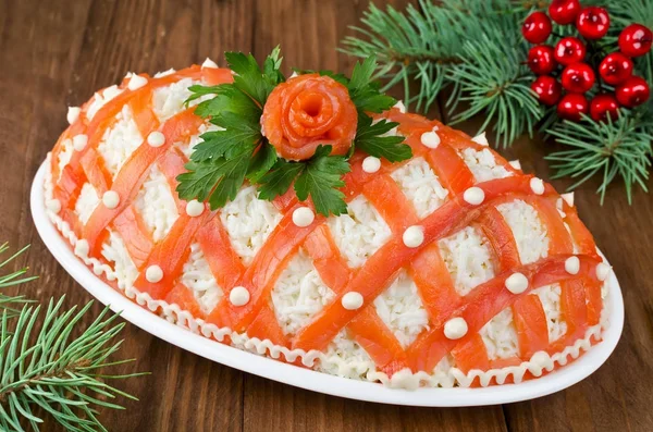 Festive salad, decorated with salmon on a wooden table — Stock Photo, Image