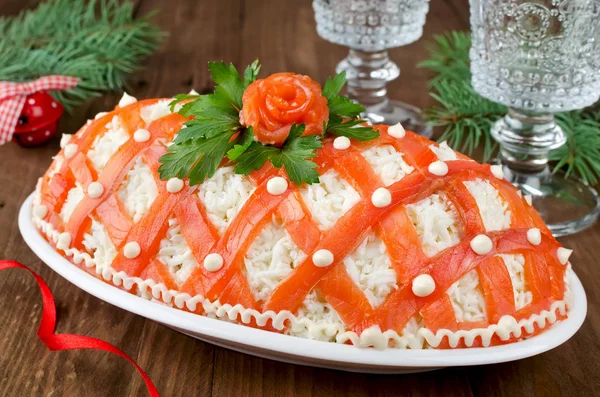 Festive salad, decorated with salmon on a wooden table — Stock Photo, Image