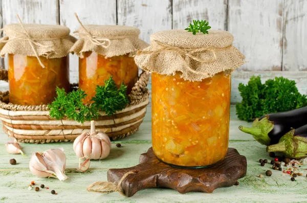 Eggplant caviar in a glass jar on a wooden table