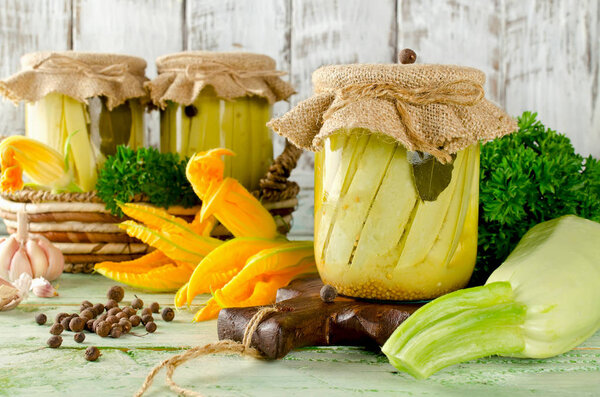 Zucchini preserve in glass jar on a wooden table