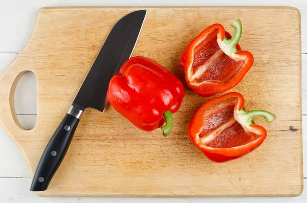 Celé a nakrájené papriky na prkénku — Stock fotografie