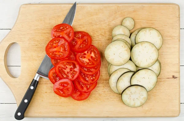 Mogna tomater och aubergine skuren i skivor på skärbräda — Stockfoto