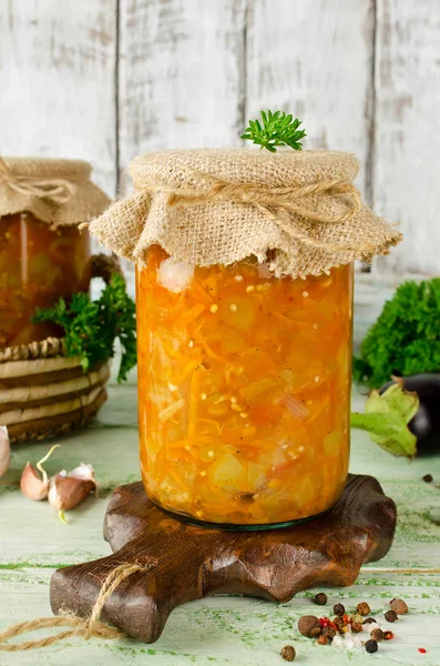 Eggplant caviar in a glass jar on a wooden table
