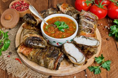 Yaprak ve pastırma kesme tahtası üzerinde sarılı Barbekü balık