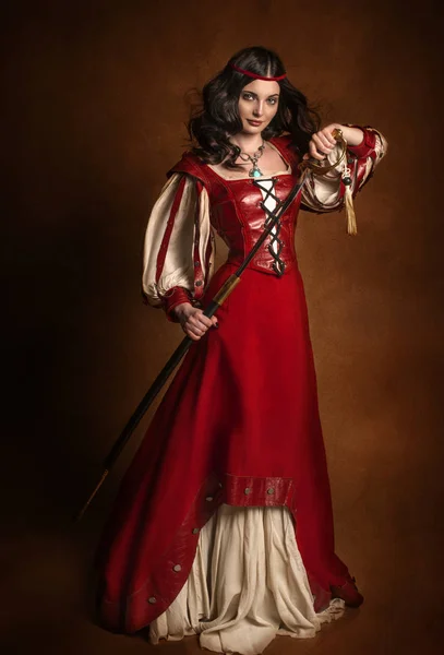 Retrato histórico de uma menina em um vestido vermelho com uma espada Fotos De Bancos De Imagens Sem Royalties