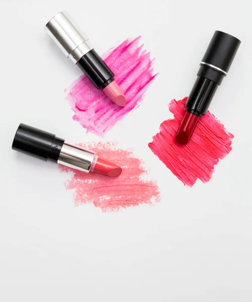 Three lipsticks with swatches on white background — Stock Photo, Image