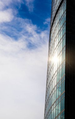 Güneşin uzun boylu ofis binası Windows'da yansıtılır. İş kavramı