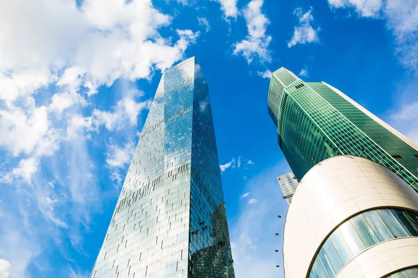 Mavi gökyüzünde güneş ışınları ile parlak güneşli bir günde gökdelen cam cepheler.