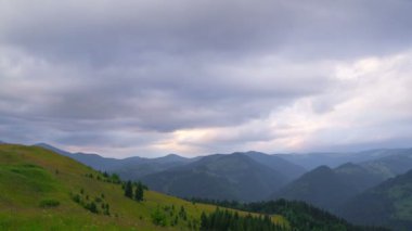 Gün batımında bulutlu dağ manzarası.