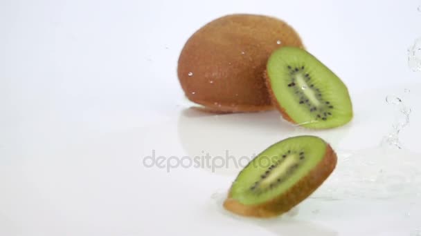 Mehrere Kiwi-Scheiben fallen auf den Tisch. — Stockvideo