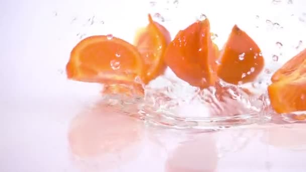 Plusieurs tranches d'orange tombent sur la table . — Video