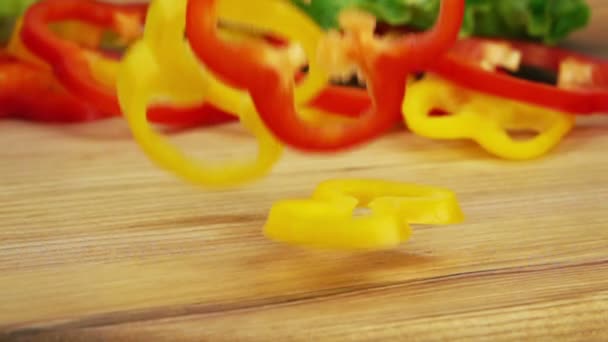 Slices of Ripe Peppers are Falling on Wooden Table. — Stock Video