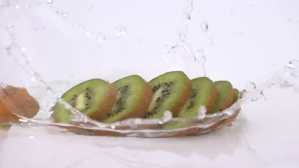 Několika plátky Kiwi klesají na stůl. — Stock video