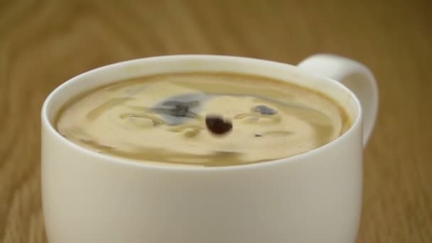 Grano de café cayendo en la taza . — Vídeo de stock