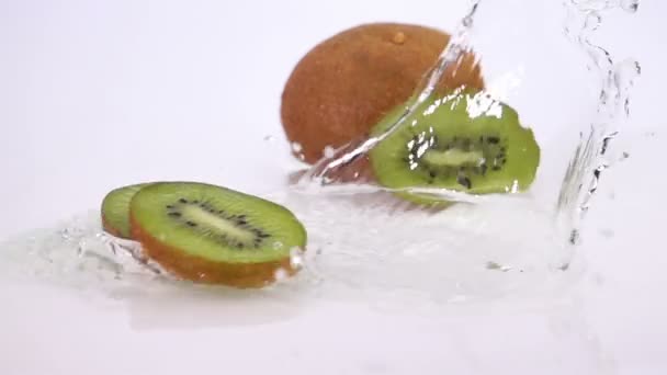 Několika plátky Kiwi klesají na stůl. — Stock video