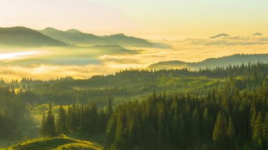 Bulutlar ve sis ile yaz dağlarda güneş doğuyor. Timelapse.