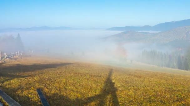 云雾缭绕的清晨 群山中有五颜六色的树木 旧篱笆和泥土路 — 图库视频影像