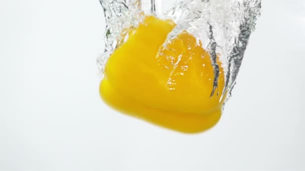 Ripe Yellow Pepper Falling Water Light Background Slow Motion — Stock Video