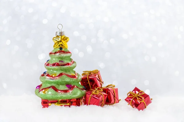 Christmas card with tree and gifts in snow, bokeh — Stock Photo, Image