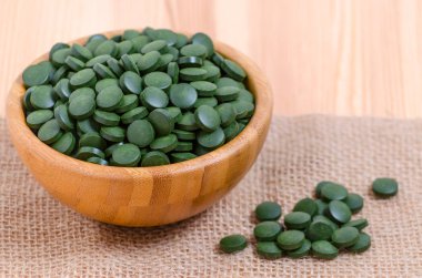 yeşil hap spirulina ve chlorella yosun yakın çekim bir ahşap kase