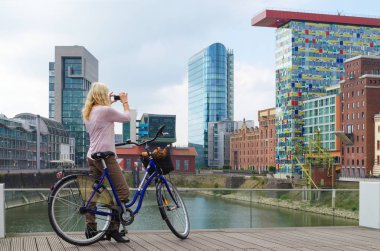 Düsseldorf, Almanya - 14 Eylül 2014: citybike jung kadınlarla alır fotoğraf binaların medya limanda
