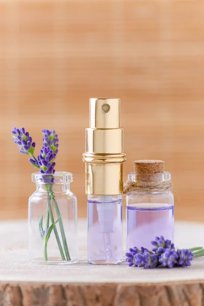lavender water in glass bottles and fresh lavender flowers for relax on brown background