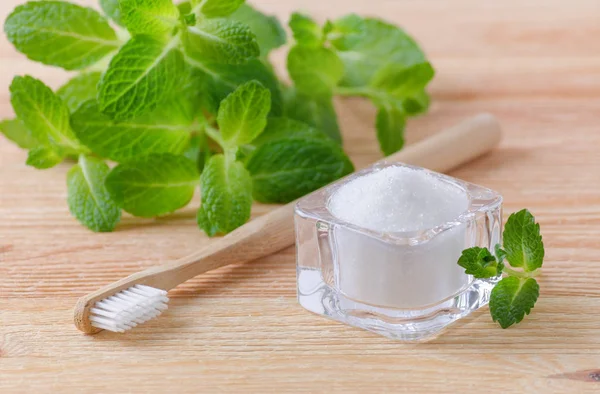 Alternative natural toothpaste xylitol, soda, salt, and wood toothbrush, mint on wooden — Stock Photo, Image