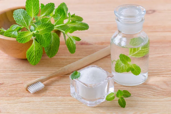 Alternatif doğal gargara şişe ile diş macunu xylitol, soda, tuz ve ahşap diş fırçası closeup, Tarih ahşap nane