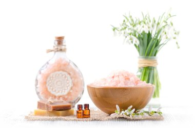 taze kardelen çiçek, sabun, eski ahşap ve beyaz arka plan üzerinde Himalaya tuz ile organik uçucu yağ ile iki şişe