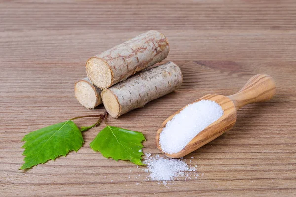 Sugar substitute xylitol, scoop with birch sugar, liefs and wood — Stock Photo, Image