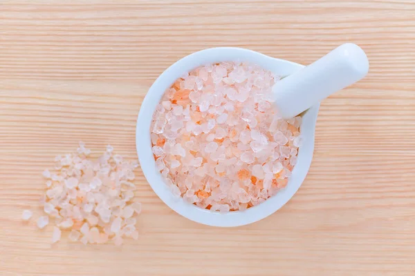 Healthy lifestyle, pink himalayan salt, mortar and pestle on wooden background, selective focus — Stock Photo, Image