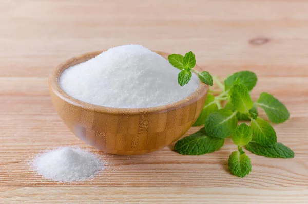 Birch sugar xylitol in a wood bowl with mint on wooden — Stock Photo, Image