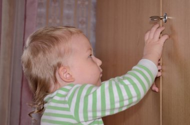 küçük çocuk deneyin evde kapıyı açmak için