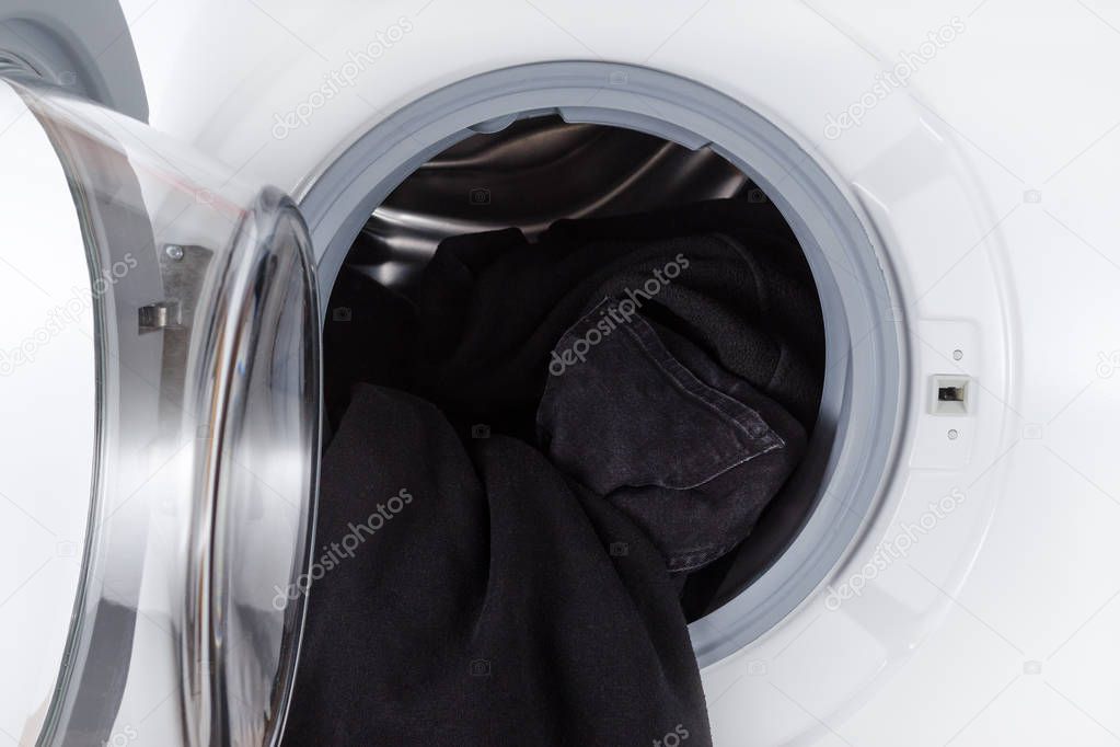 washing black clothes, open wash machine closeup