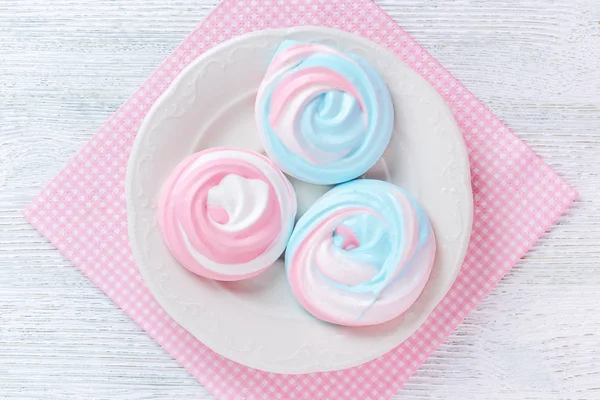 Meringues aux couleurs pastel avec motif abstrait sur une assiette et une serviette rose — Photo