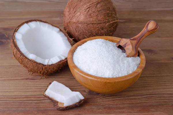 Flocos de coco em uma tigela em fundo de madeira — Fotografia de Stock