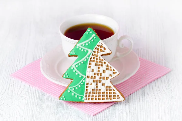 Christmas tree gingerbread with coffe cup on wooden table with pink napkin — Stock Photo, Image