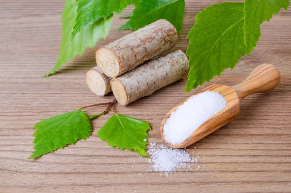 Sugar substitute xylitol, scoop with birch sugar, liefs and wood — Stock Photo, Image