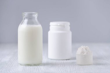 cam şişe süt ve toz gri arka plan üzerinde