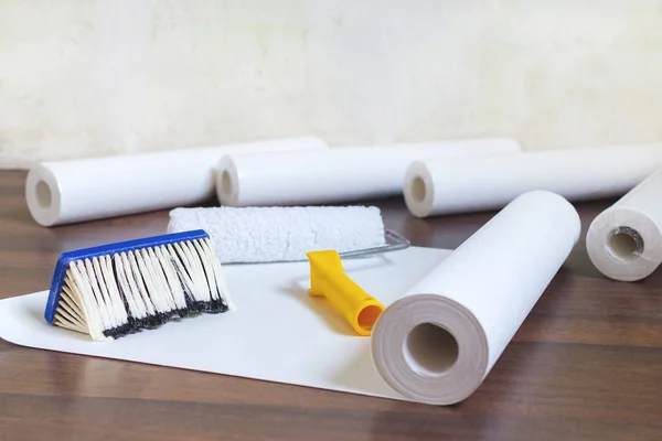 Preparación para la reparación del hogar, rollos de papel pintado y cepillo en el suelo —  Fotos de Stock