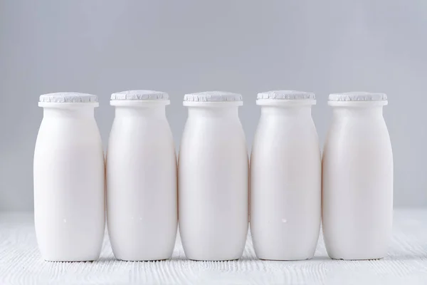 Cinco botellas de yogur de bebida sobre fondo gris —  Fotos de Stock