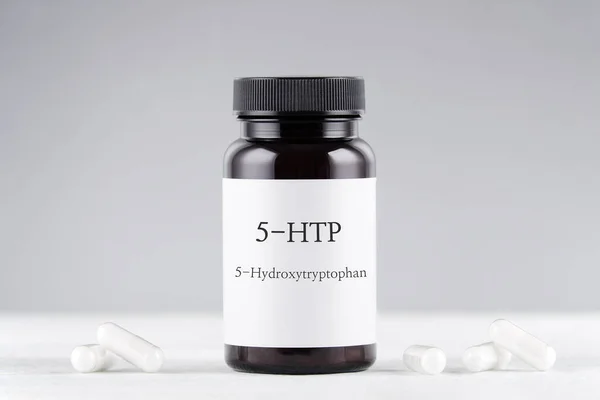 Suplemento nutricional 5-HTP hidroxitriptófano, botella y cápsulas en gris —  Fotos de Stock