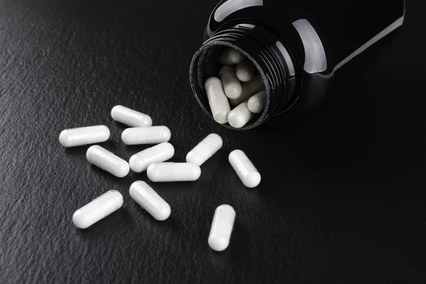 food supplement capsules on black background closeup