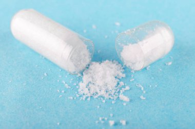 Bir açık kapsül besin takviyesi msm, sülfür, mavi arkaplan