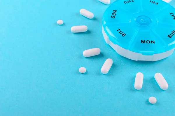 Různé léky na jeden týden a tabletky na modrém pozadí s prostorem pro kopírování — Stock fotografie