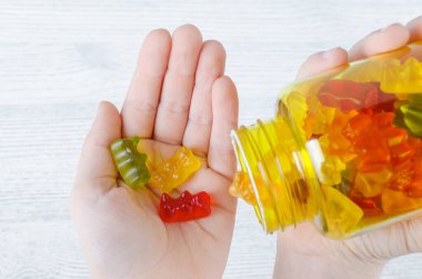 Çocuk, çocuklar için şeker gibi vitamin tutuyor.