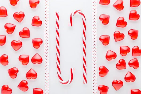 white background with red hearts and christmas candy cane