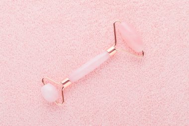 Gerçek gül kuvars yüz silindiri pastel pembe arka planda, düz uzanmış