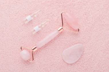 Gerçek gül kuvars yüz silindiri, gua sha masaj taşı ve ampullerde yüz serumu.