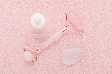 Gül kuvars yüz silindiri, masaj taşı ve yüz serumu.